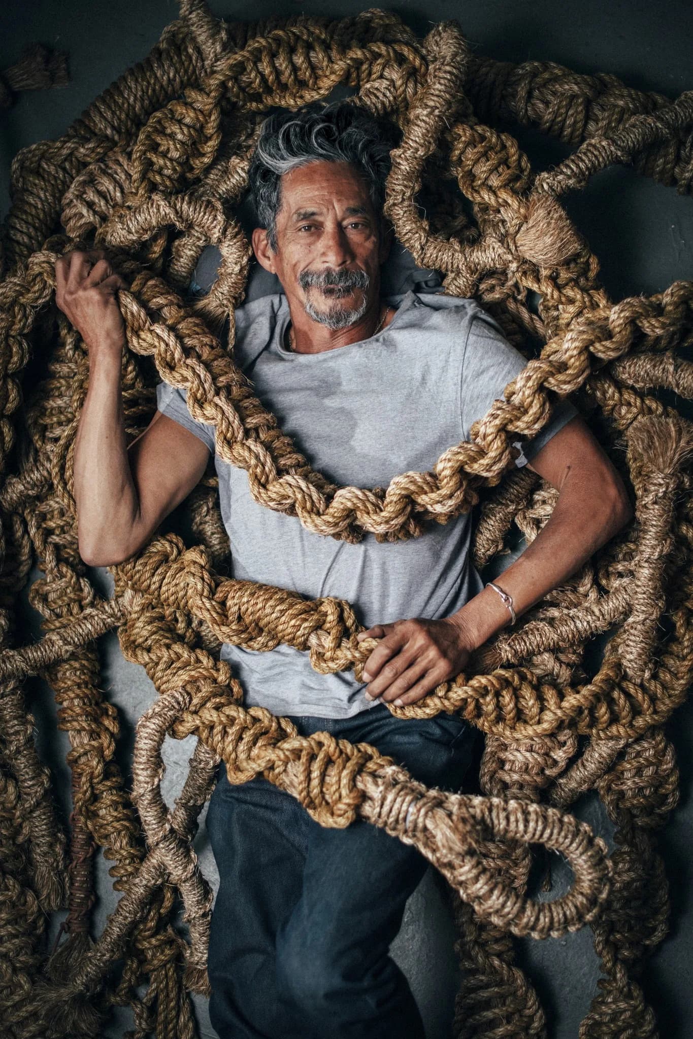 Ropemaker wrapped in coils of natural rope