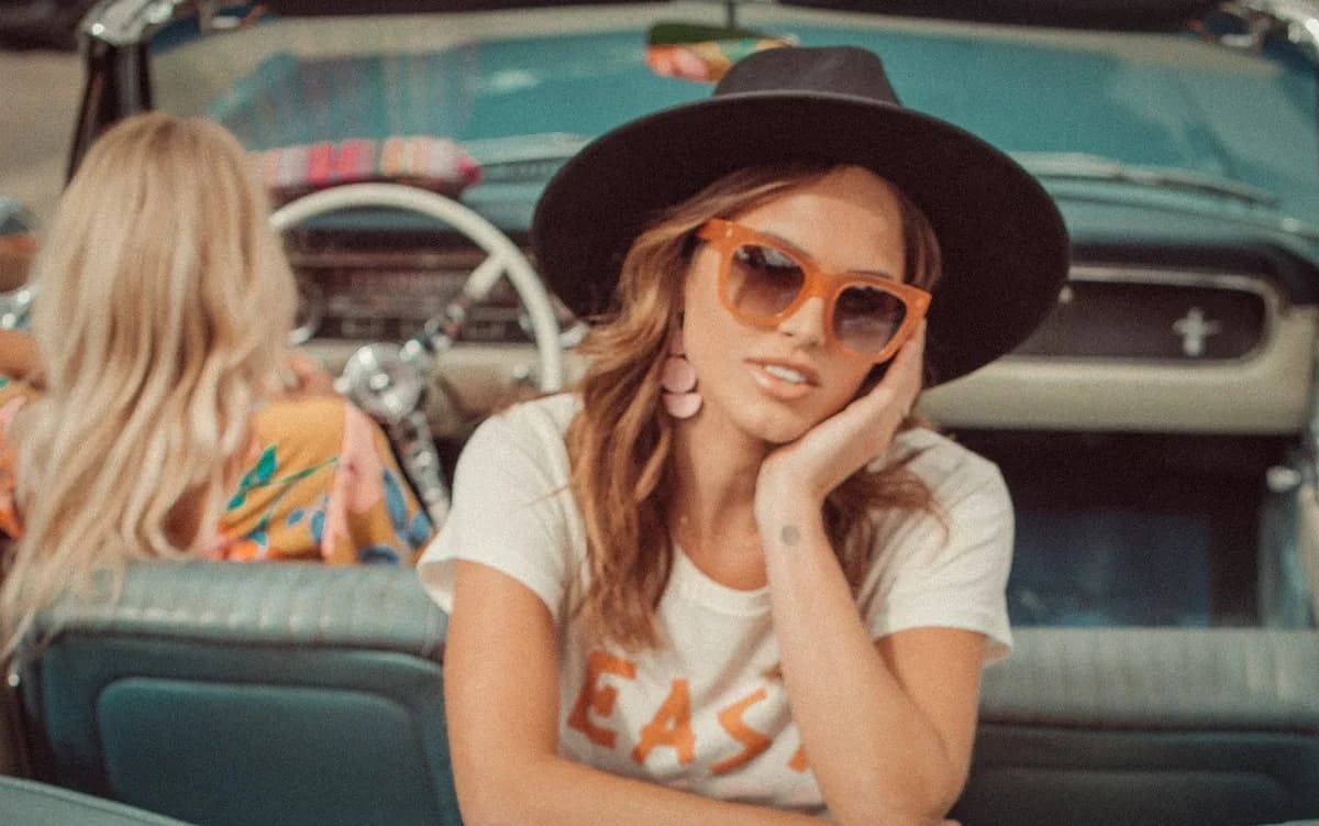 Model in amber sunglasses in a classic car