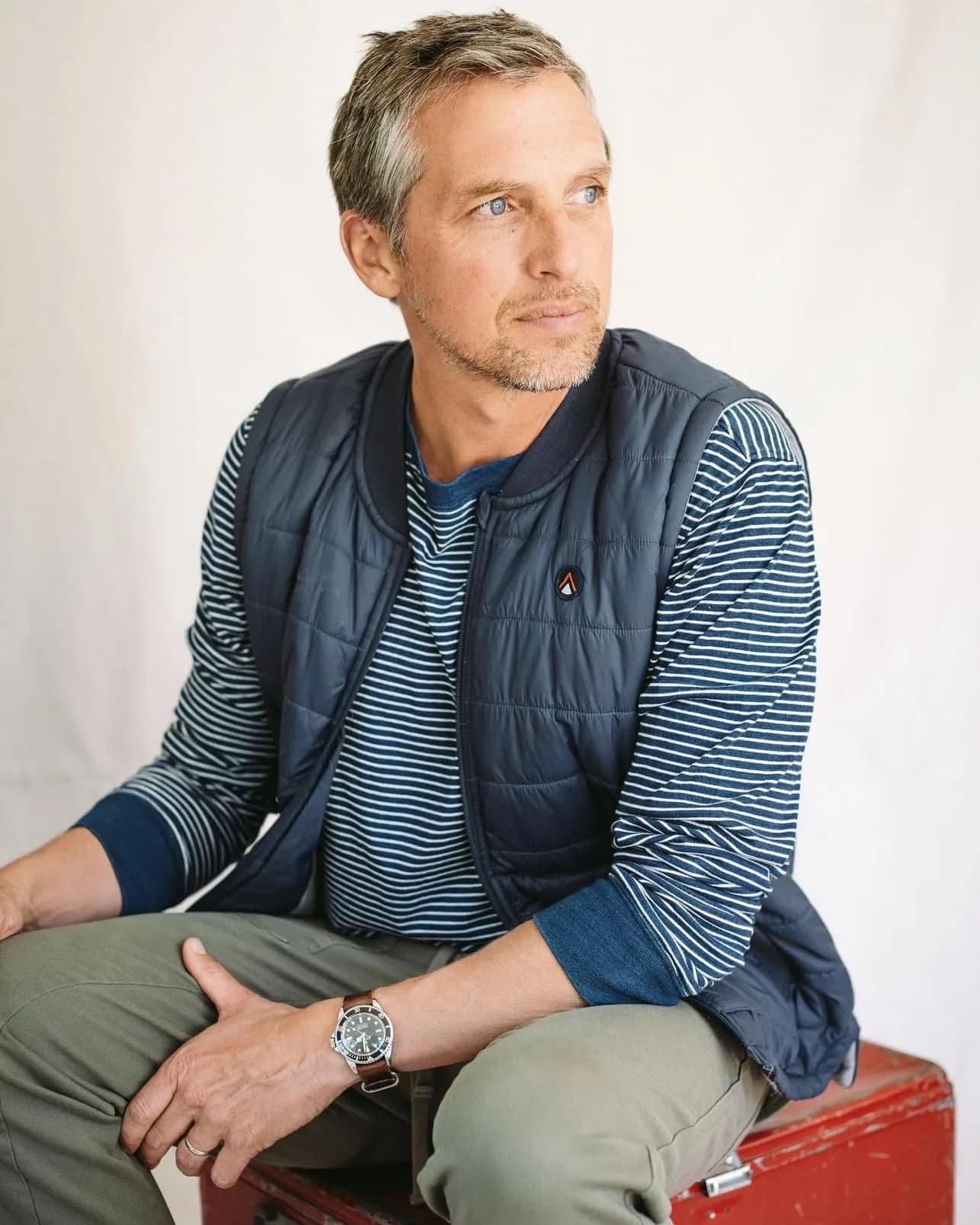 Menswear editorial, navy vest, seated